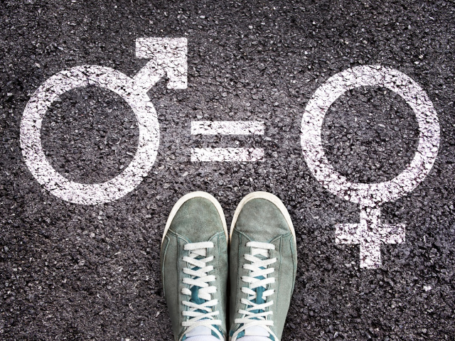 Sneaker shoes on asphalt background with gender symbols, gender equality education concept
