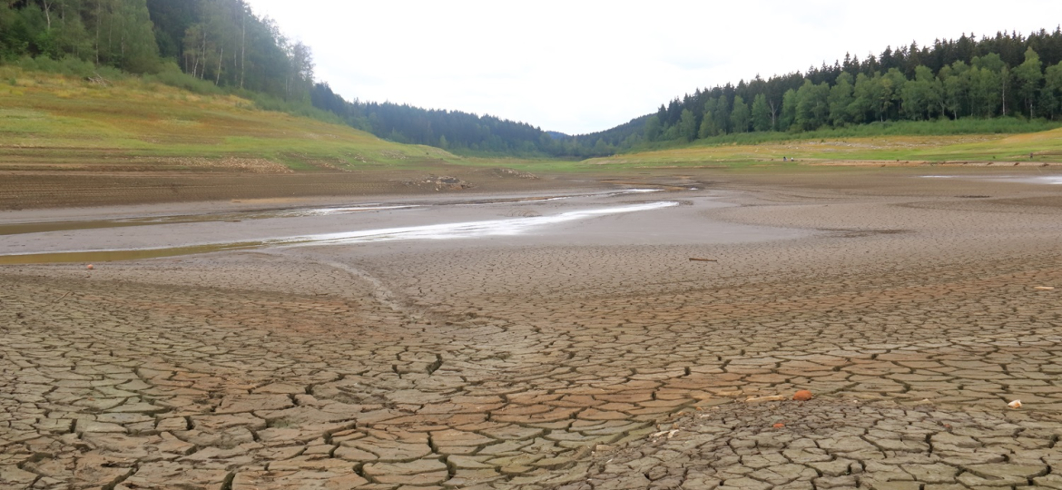 A dried up empty reservoir and dam during a summer heatwave, low rainfall and drought in Saxony, Germany, Talsperre Lehnmuehle